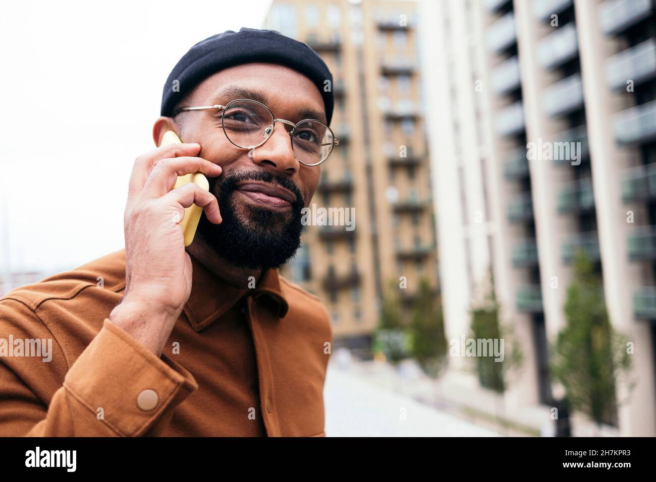 Smiling bearded man talking on smart phone Stock Photo