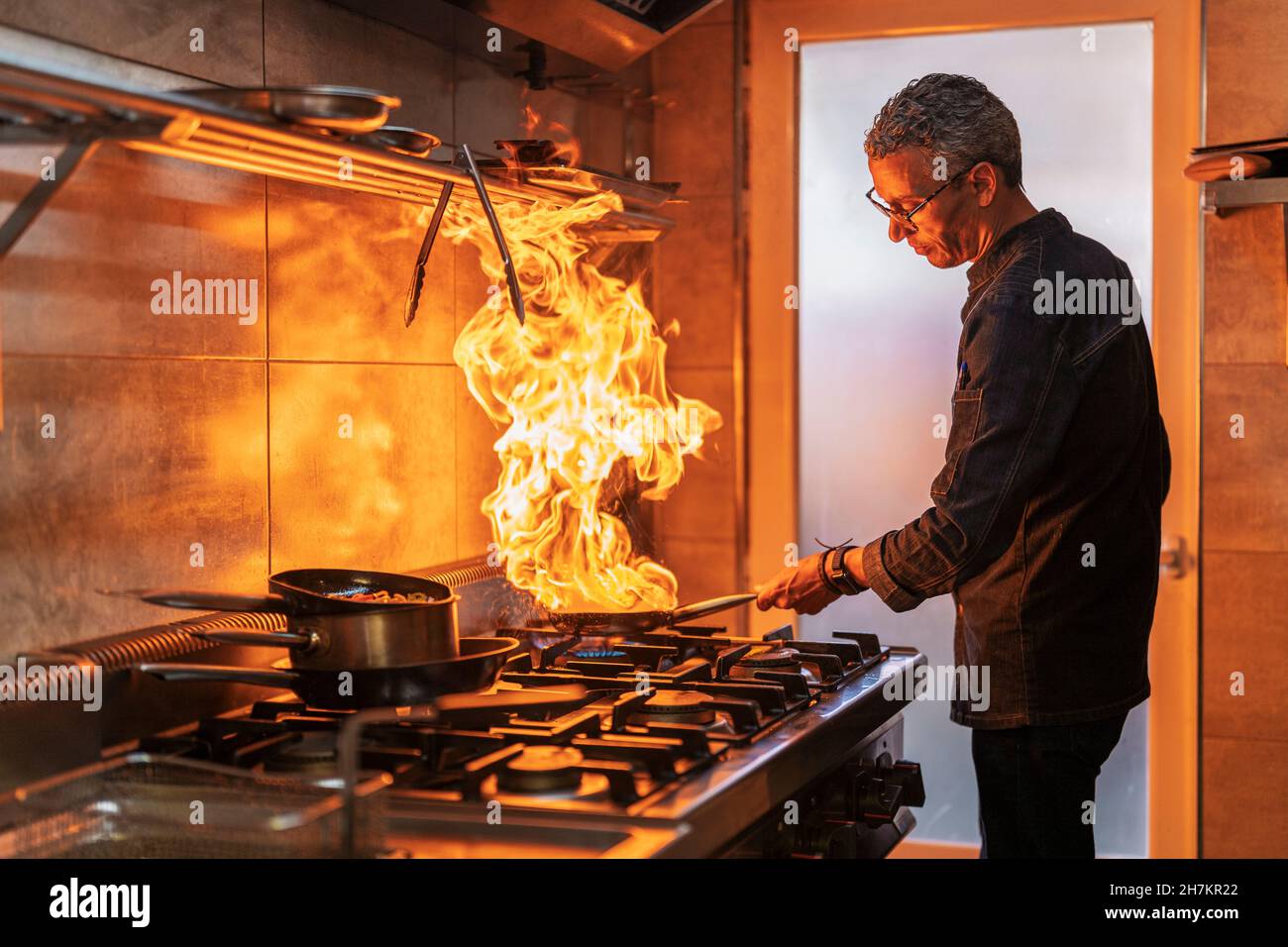 Male chef holding pan while cooking in restaurant Stock Photo Alamy