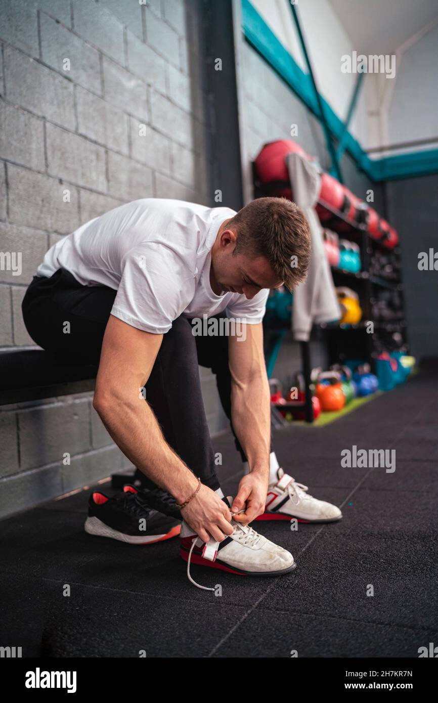 Young male athlete tying shoelace in gym Stock Photo