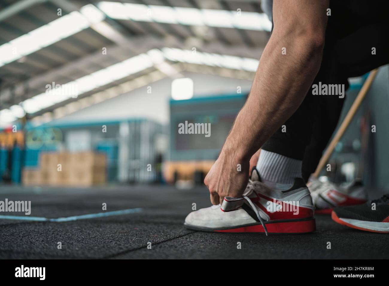 Male athlete tying shoelace in gym Stock Photo