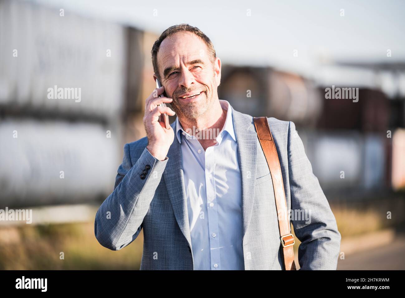 Smiling businessman talking over mobile phone Stock Photo