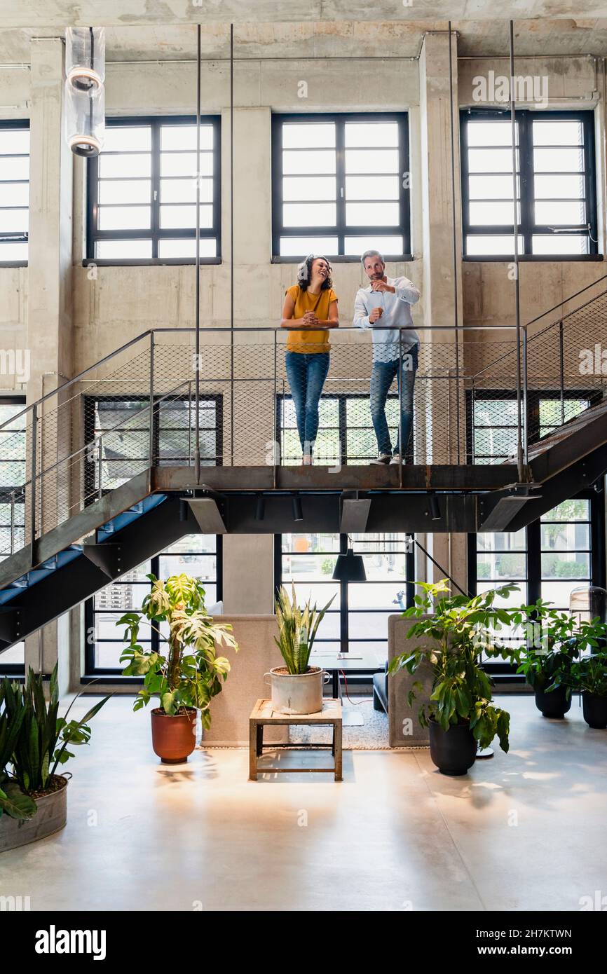 Coworkers having discussion at office staircase Stock Photo