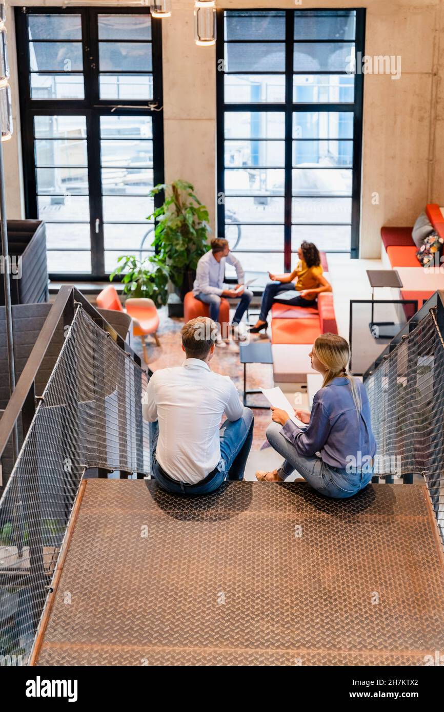 Young coworkers having discussion on office staircase Stock Photo