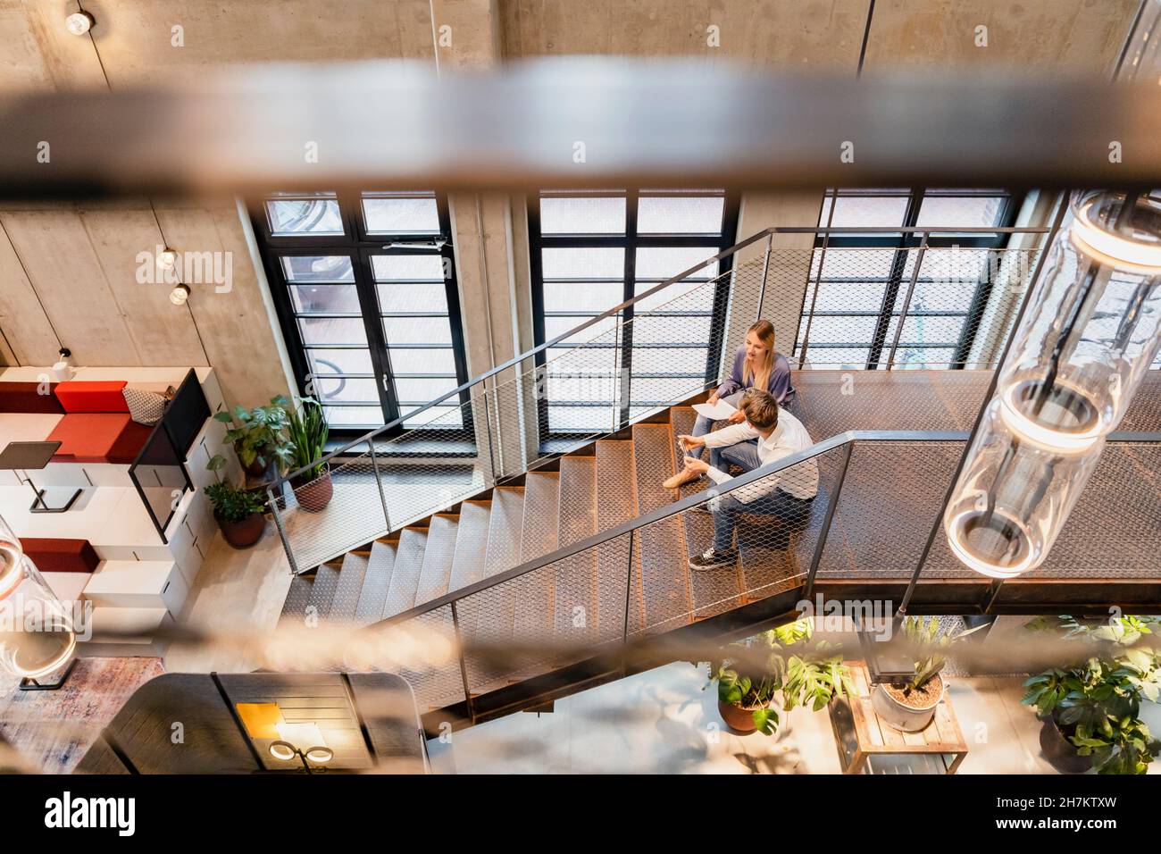 Coworkers having discussion at office staircase Stock Photo