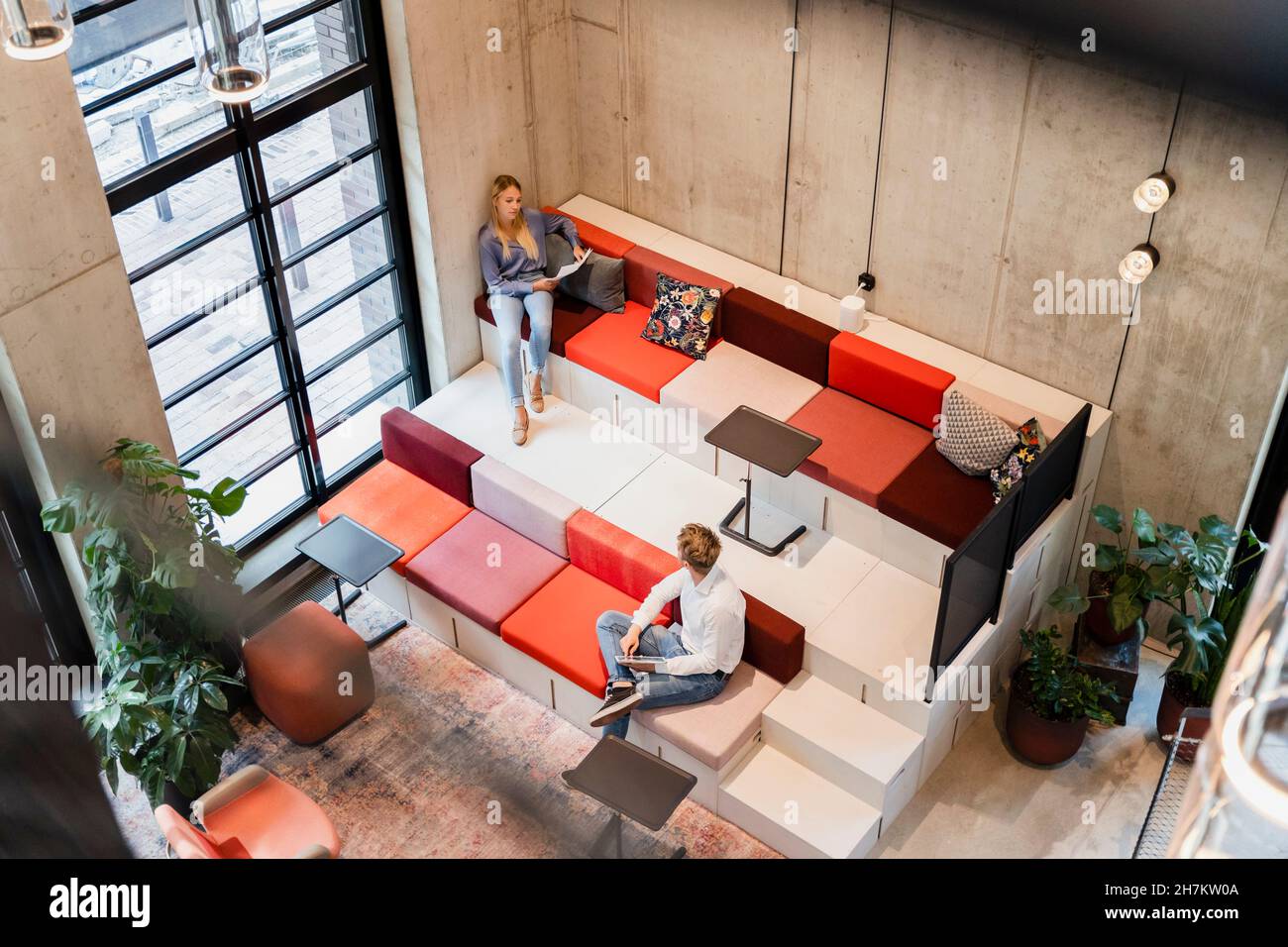 Young colleagues discussing while working at workplace Stock Photo