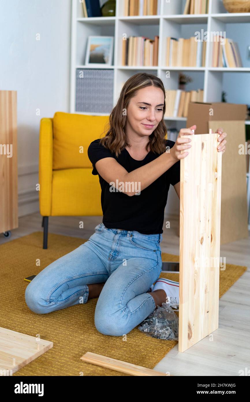 Young woman assembling piece of furniture Stock Photo
