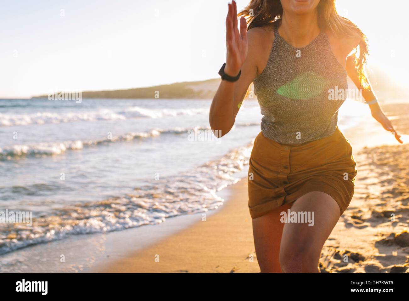 Woman running on shore at beach Stock Photo