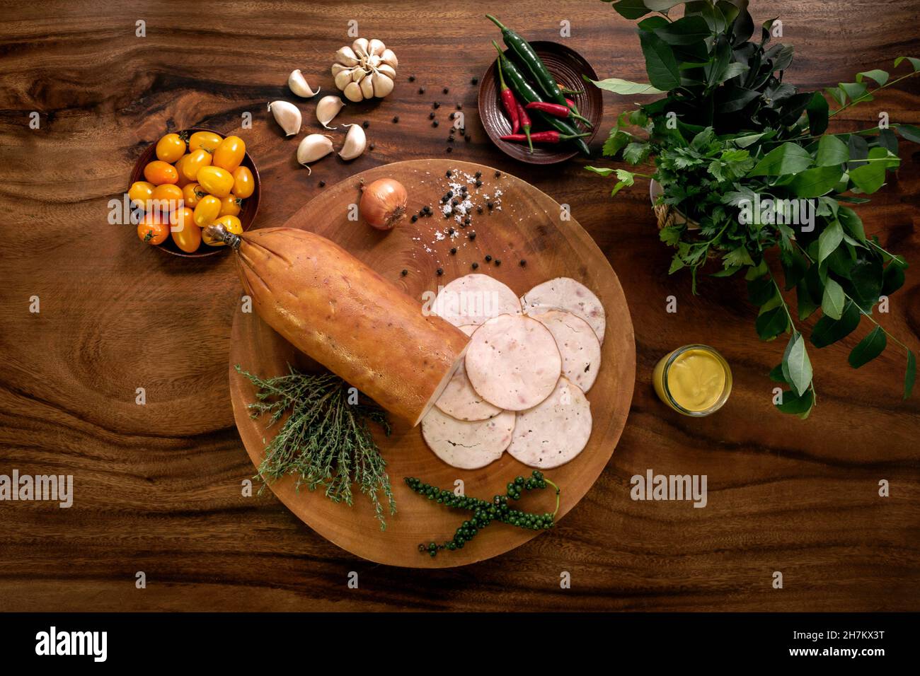 smoked chicken ham on rustic wood table with natural ingredients arrangement Stock Photo