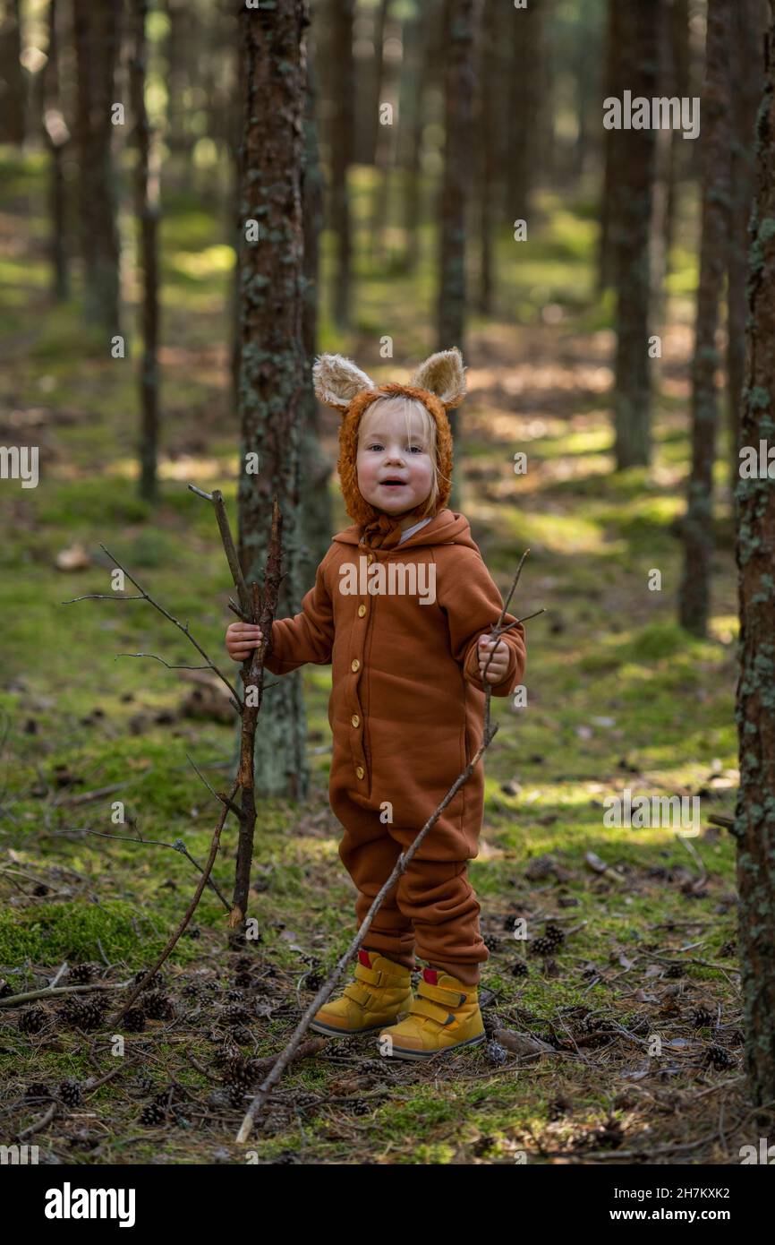 Smiling girl holding sticks in forest Stock Photo - Alamy