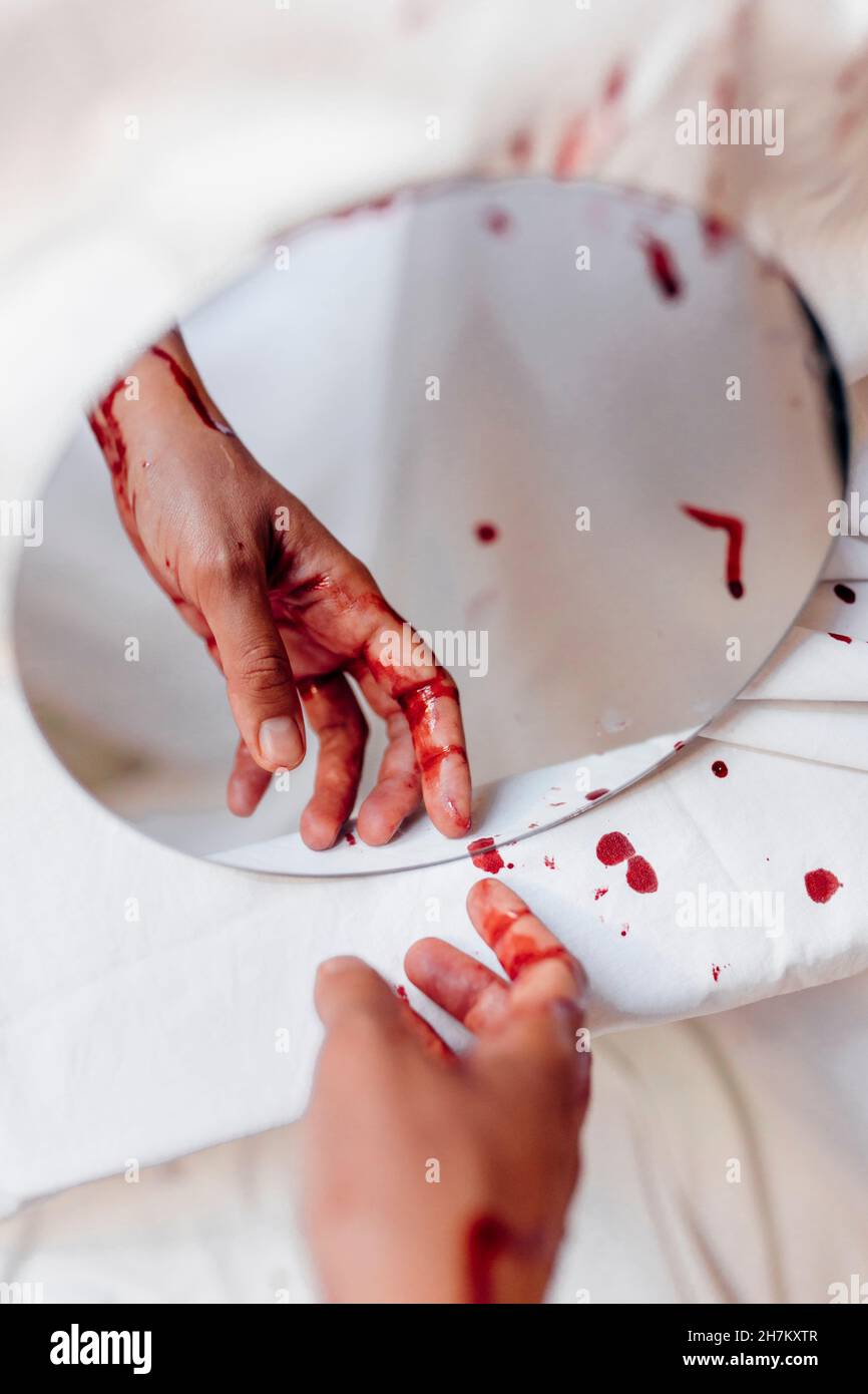 Reflection of bleeding hand on mirror Stock Photo