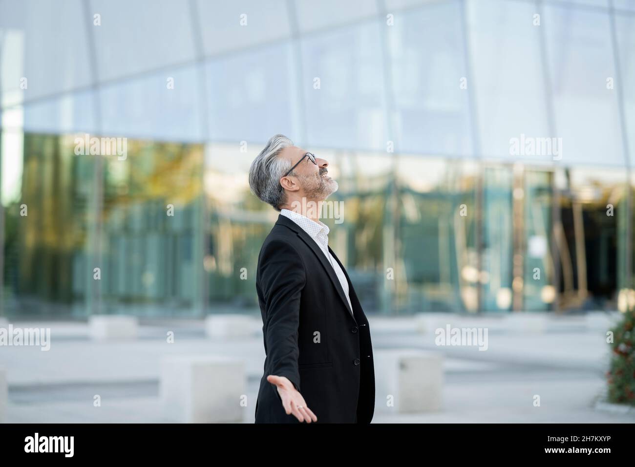Businessman sitting cross-legged relaxing on seat Stock Photo - Alamy