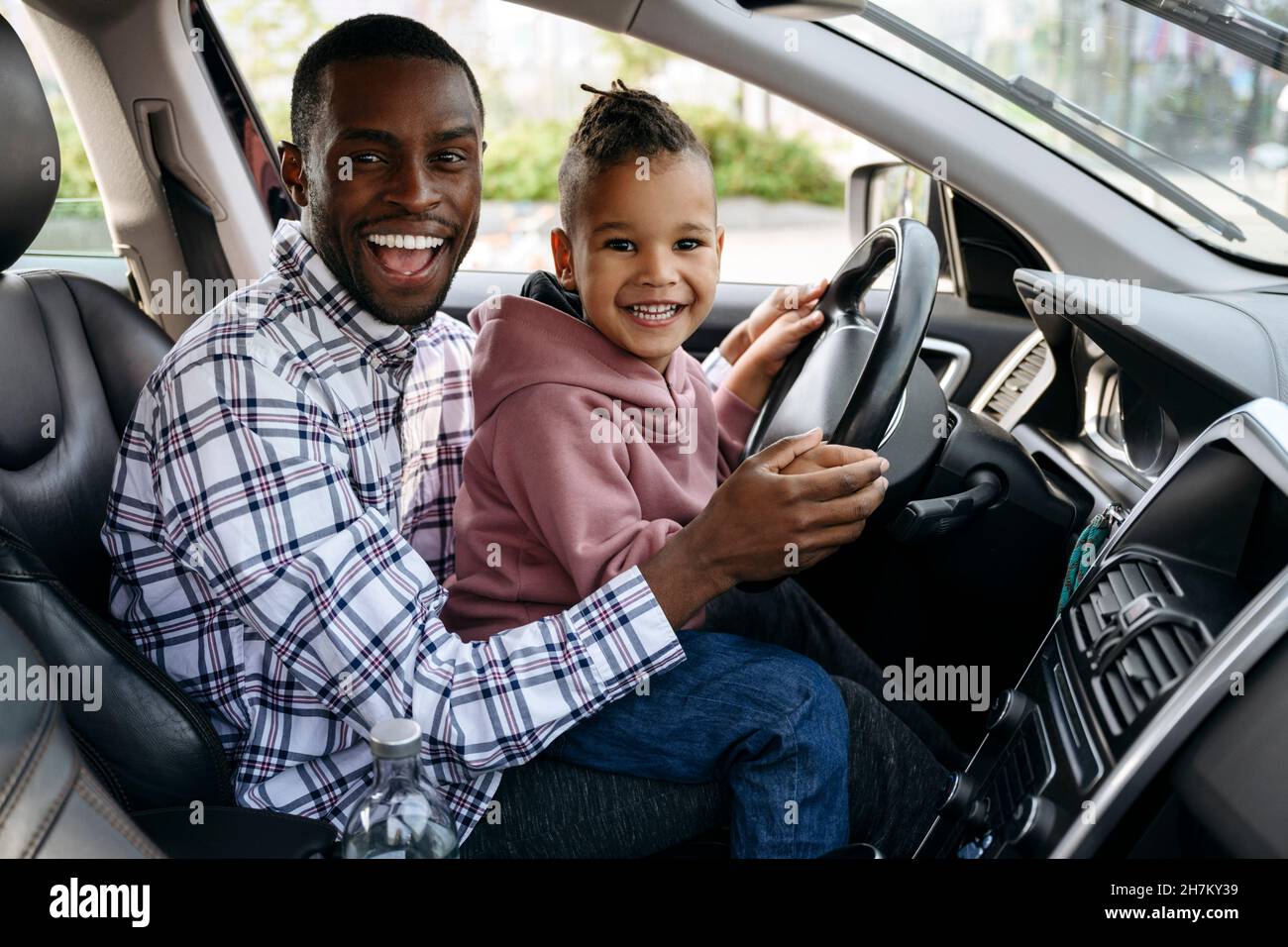 Son and father playing with steering wheel in car Stock Photo Alamy