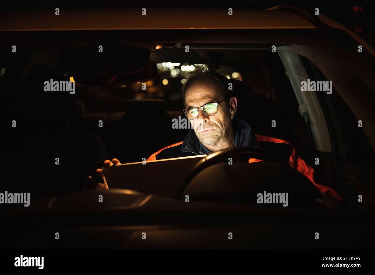 Engineer wearing eyeglasses using laptop in car Stock Photo