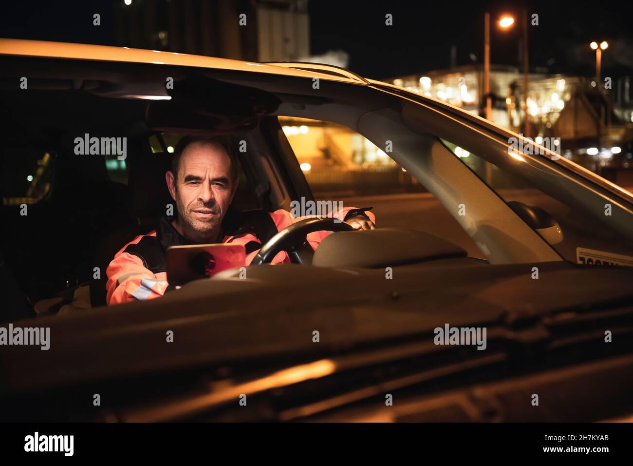 Engineer using tablet PC in car at night Stock Photo