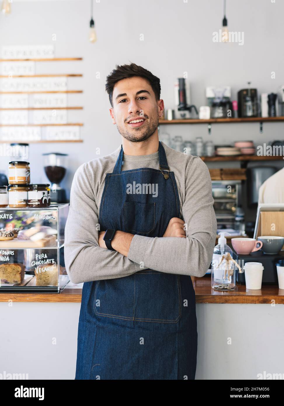 Man with apron using mobile phone in cafe Stock Photo