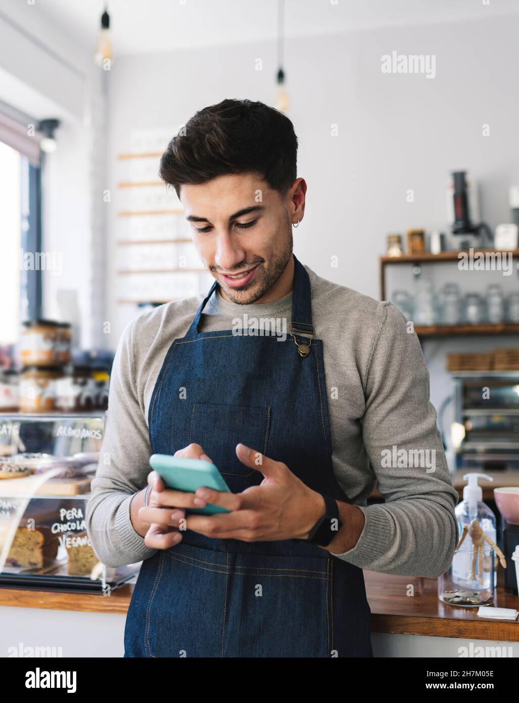 Waiter using smart phone in coffee shop Stock Photo Alamy