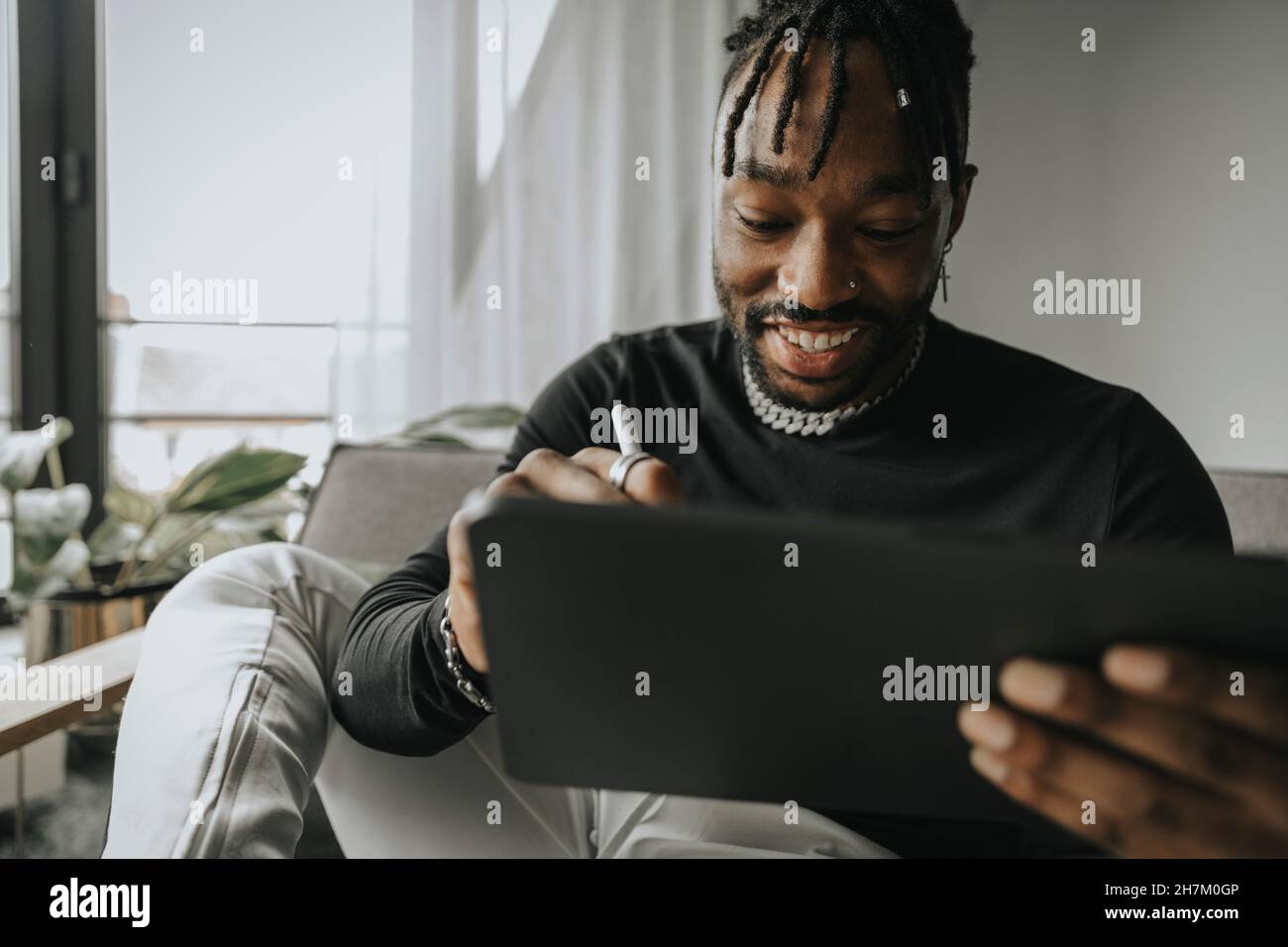 Smiling man using tablet PC at home Stock Photo