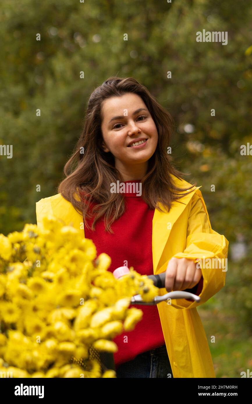 Smiling woman with flowers on bicycle Stock Photo