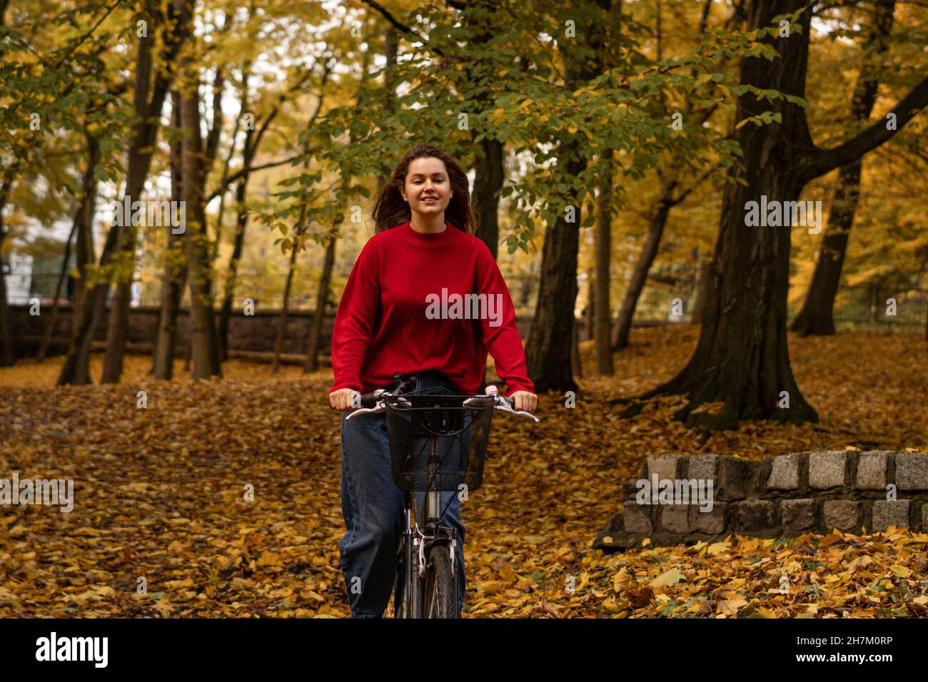 Smiling woman cycling at autumn park Stock Photo