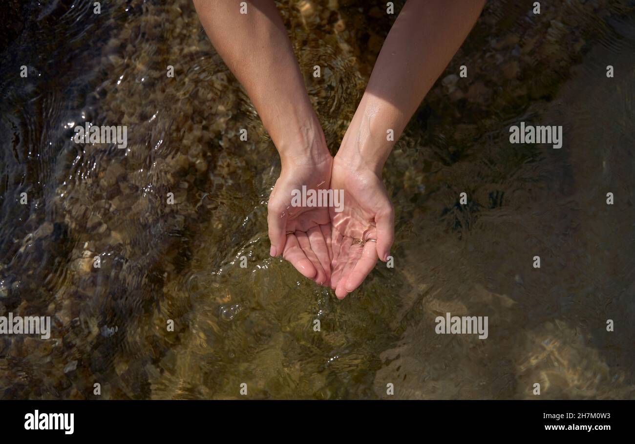 Woman with hands cupped holding water Stock Photo