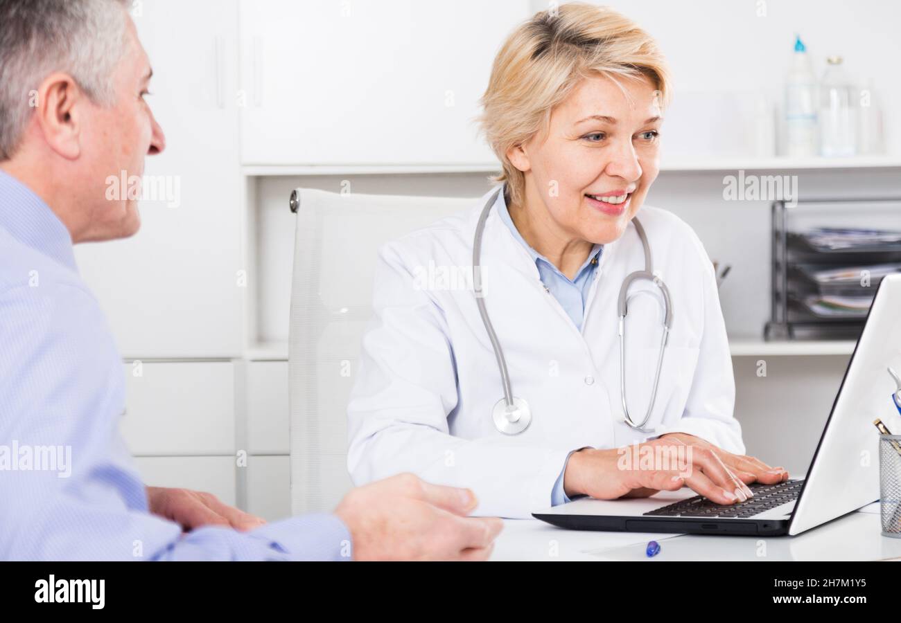 Mature female doctor listens hi-res stock photography and images - Alamy