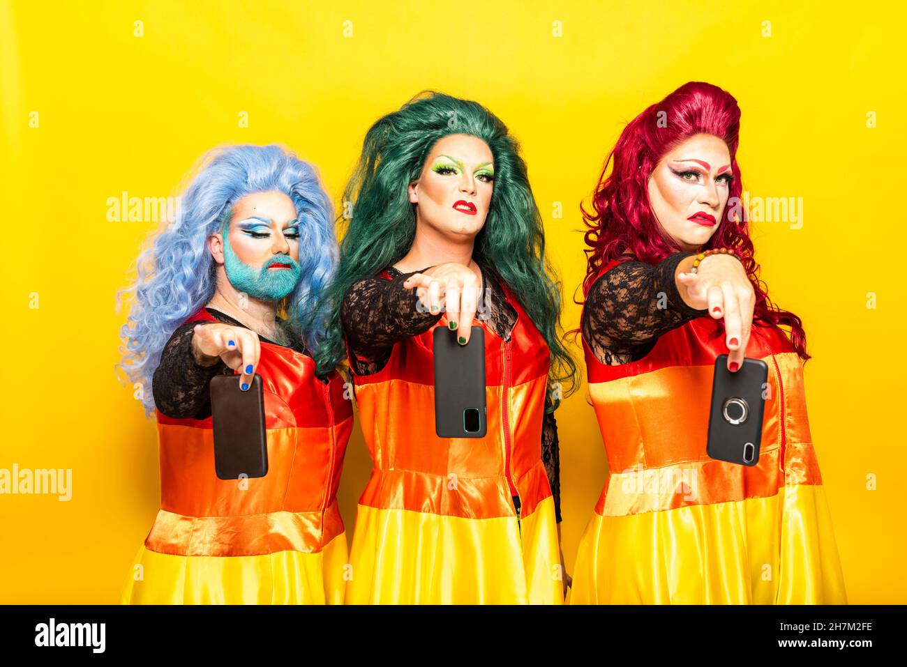 Drag queen with mouth open and hand in wig against white background