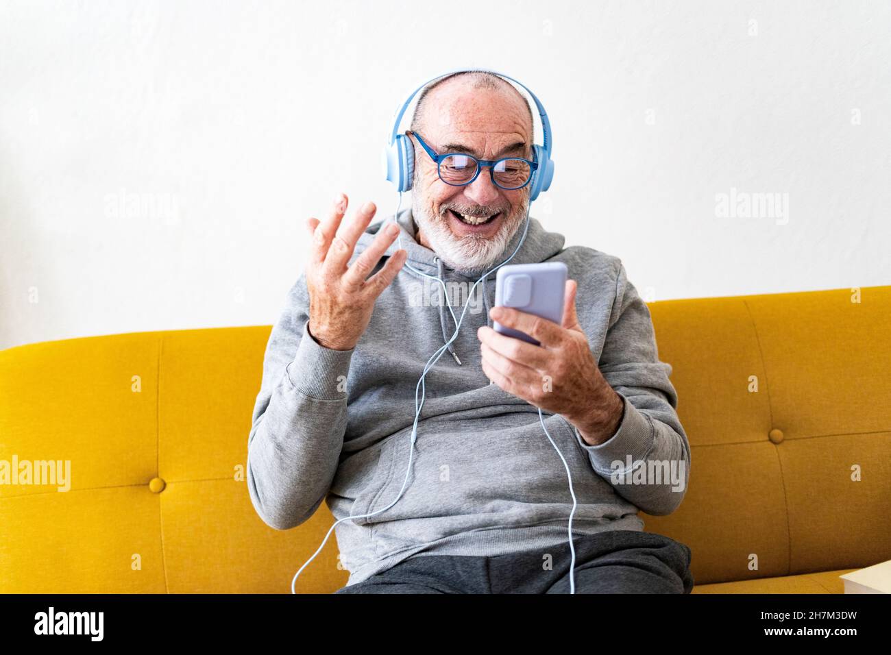 Smiling senior man drinking coffee on sofa Stock Photo