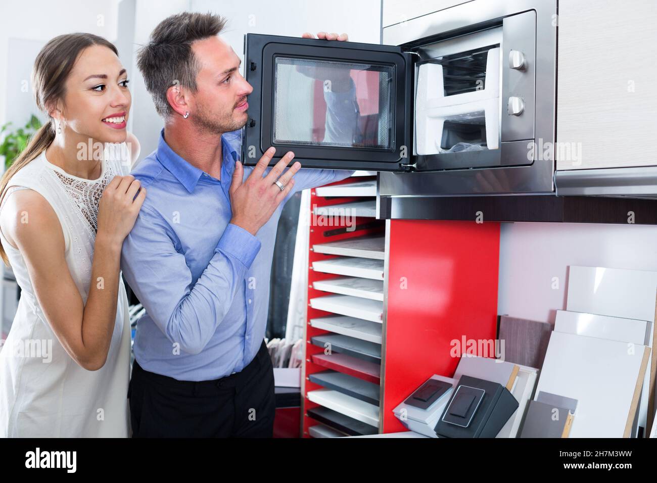 Smiling couple are choosing new microwave Stock Photo
