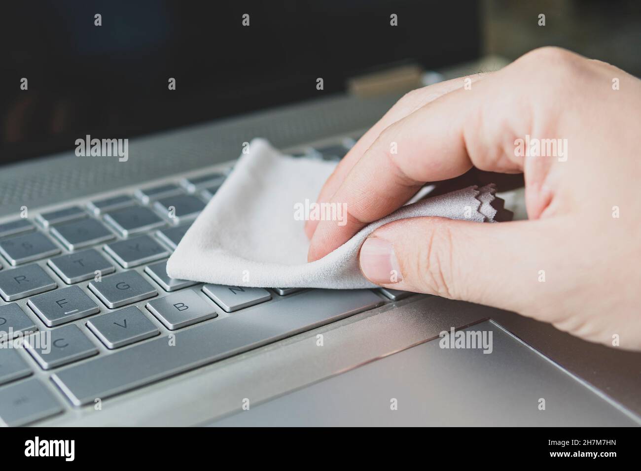 man panic cleaning notebook laptop pc. cleaning the dust from the keys