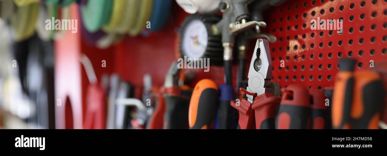 Many working tools hanging on wall in workshop closeup Stock Photo