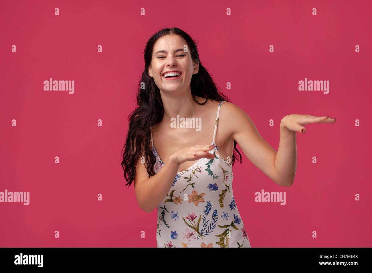 Portrait of a pretty young woman in a light dress standing on pink ...