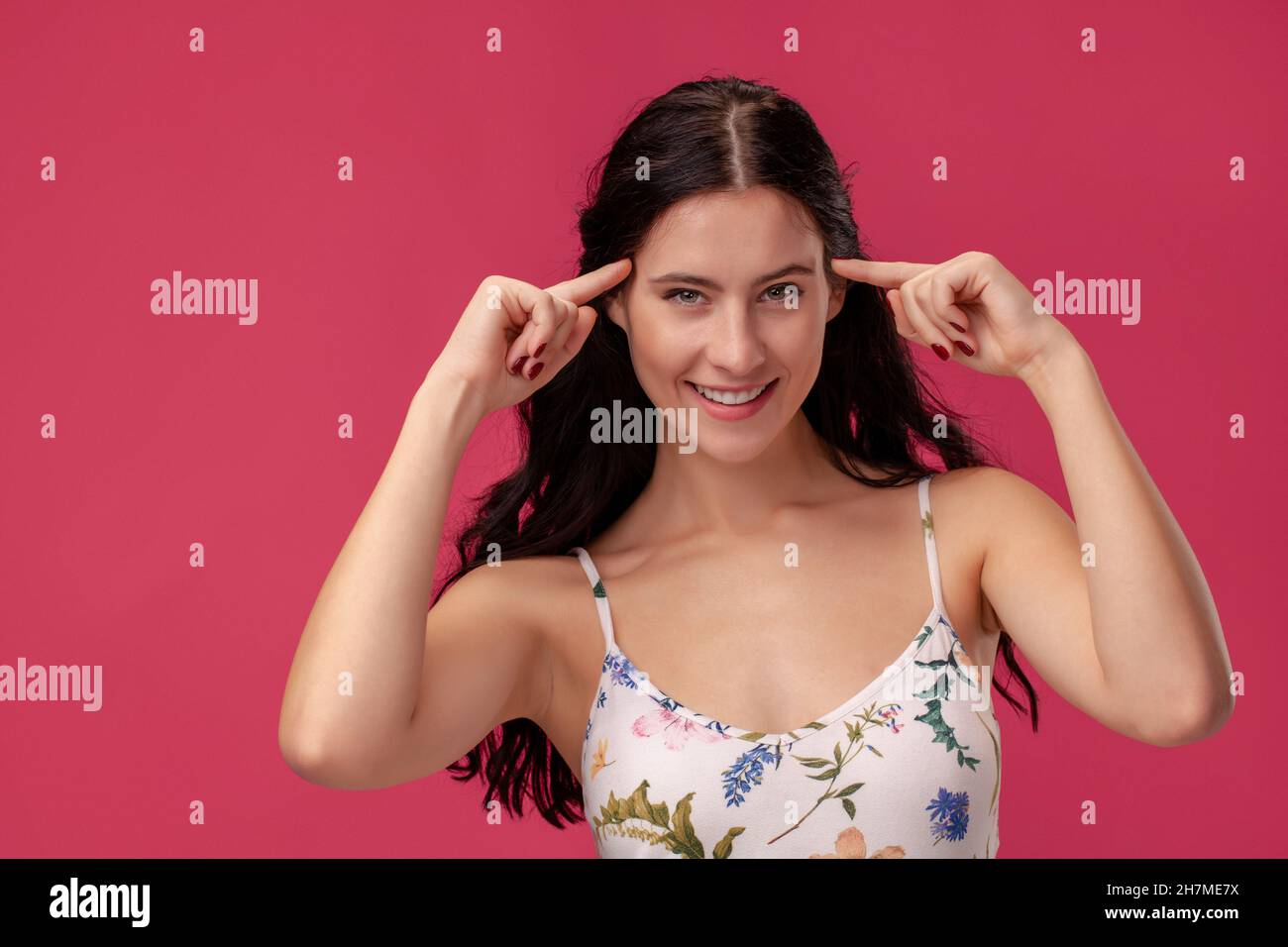 Portrait of a pretty young woman in a light dress standing on pink ...