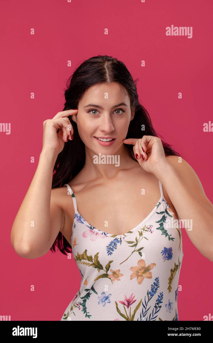 Portrait of a pretty young woman in a light dress standing on pink ...