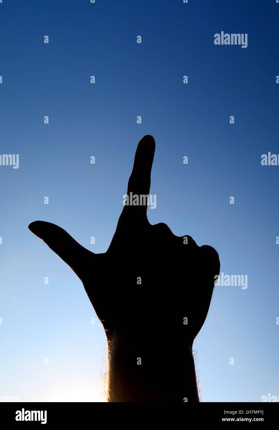 Hand Silhouette with Finger Up on the Sky Background closeup Stock Photo