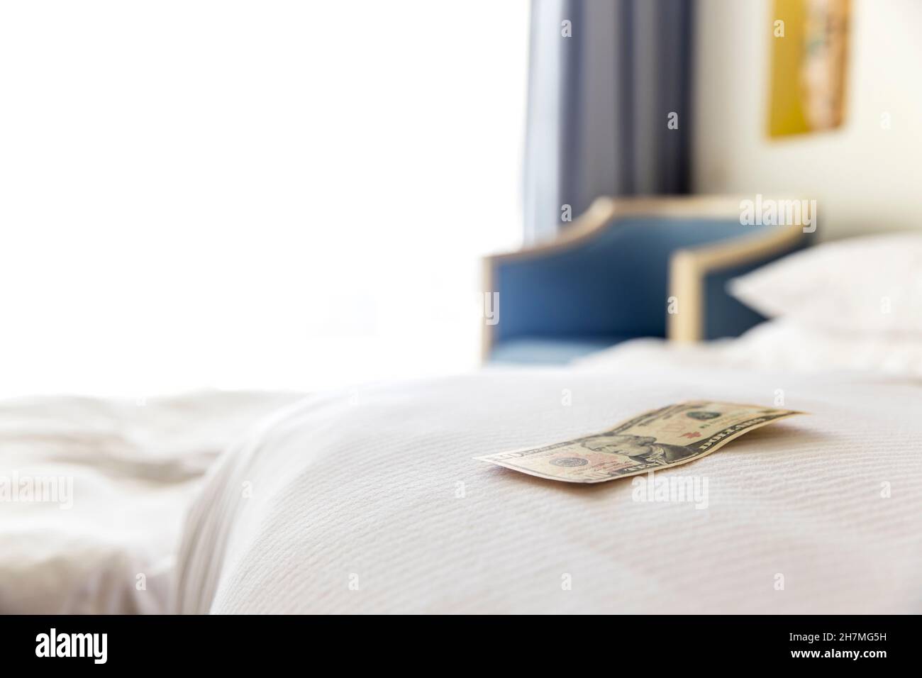 Traditional tips is laying on the corner of bed in hotel room for room