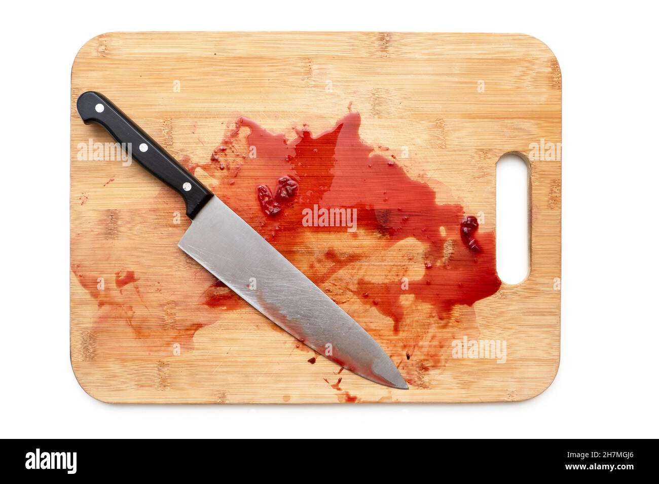 Cutting board with bloody surface and knife isolated on white. Top view Stock Photo