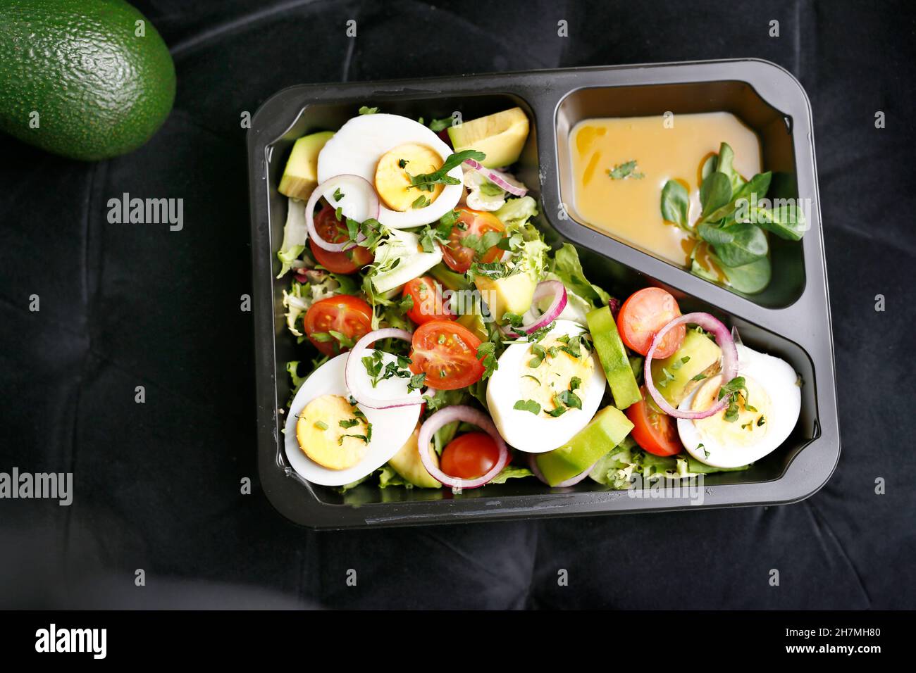 Diet box with egg and avocado salad, appetizing take-away meal. Appetizing ready-to-go dish served in a disposable box. Culinary photography.y photog Stock Photo
