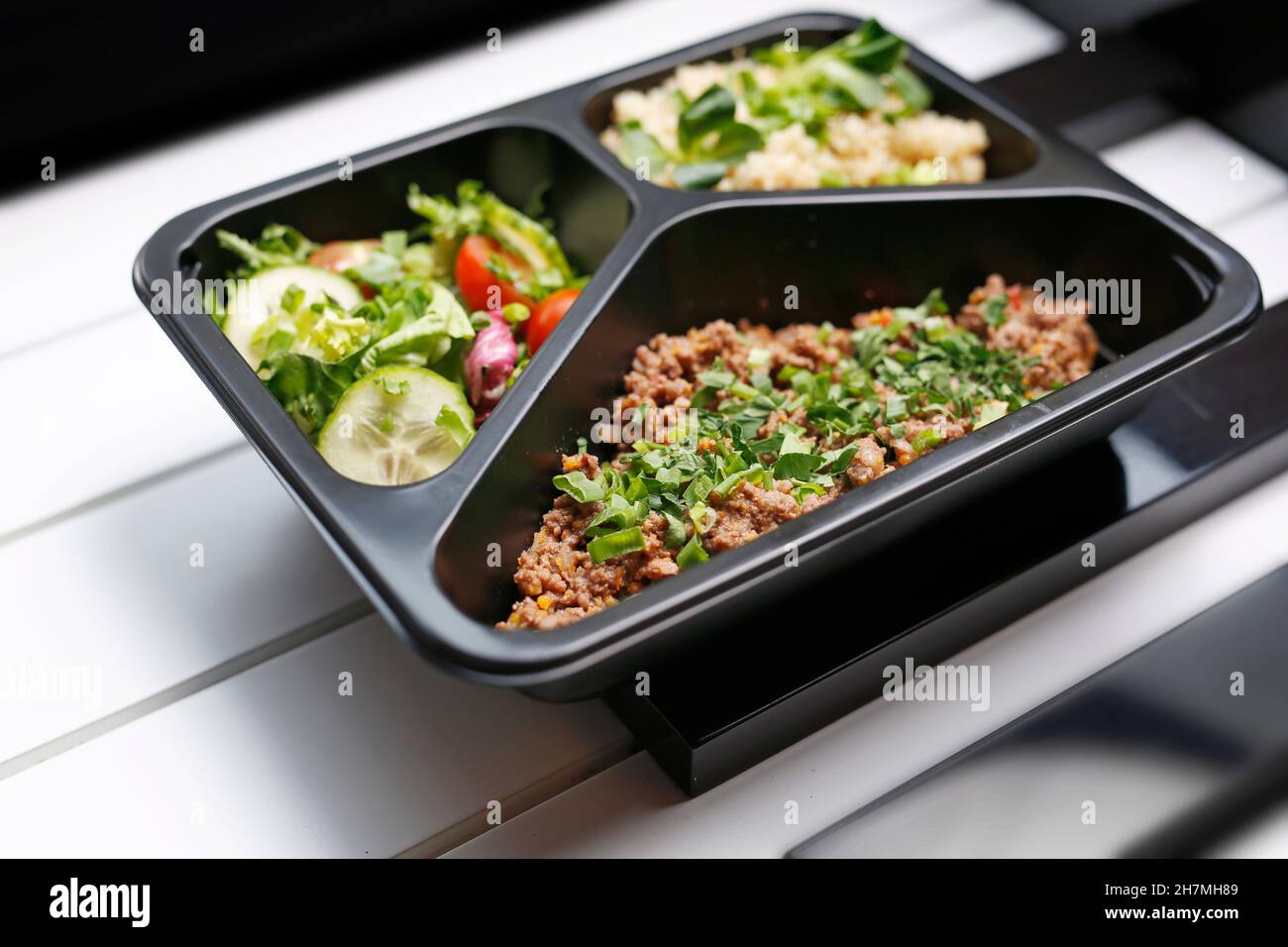 Box diet, appetizing take-away lunch. Appetizing ready-to-go dish served in a disposable box. Culinary photography. Food background. Stock Photo