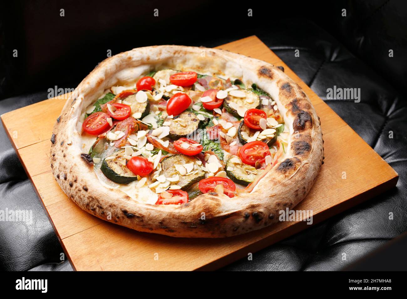 Pizza with eggplant, spinach and tomatoes. A tasty dish.Culinary photography. Suggestion to serve the dish. Stock Photo