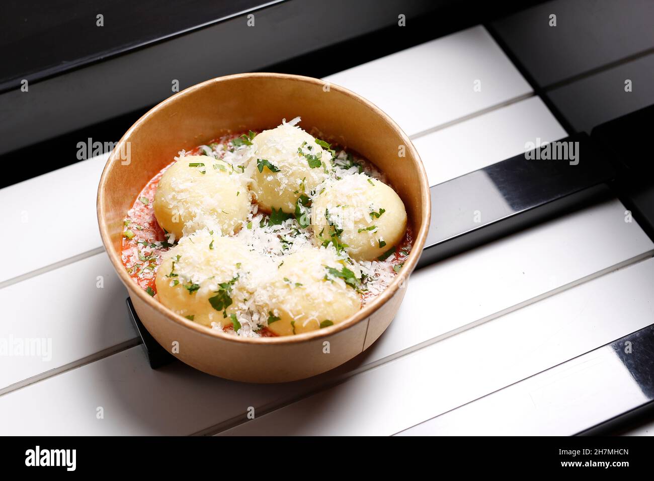 Gnocchi di patate, potato dumplings with tomato sauce, and Parmesan cheese. Takeaway, diet box. Appetizing ready-to-go dish served in a disposable bo Stock Photo