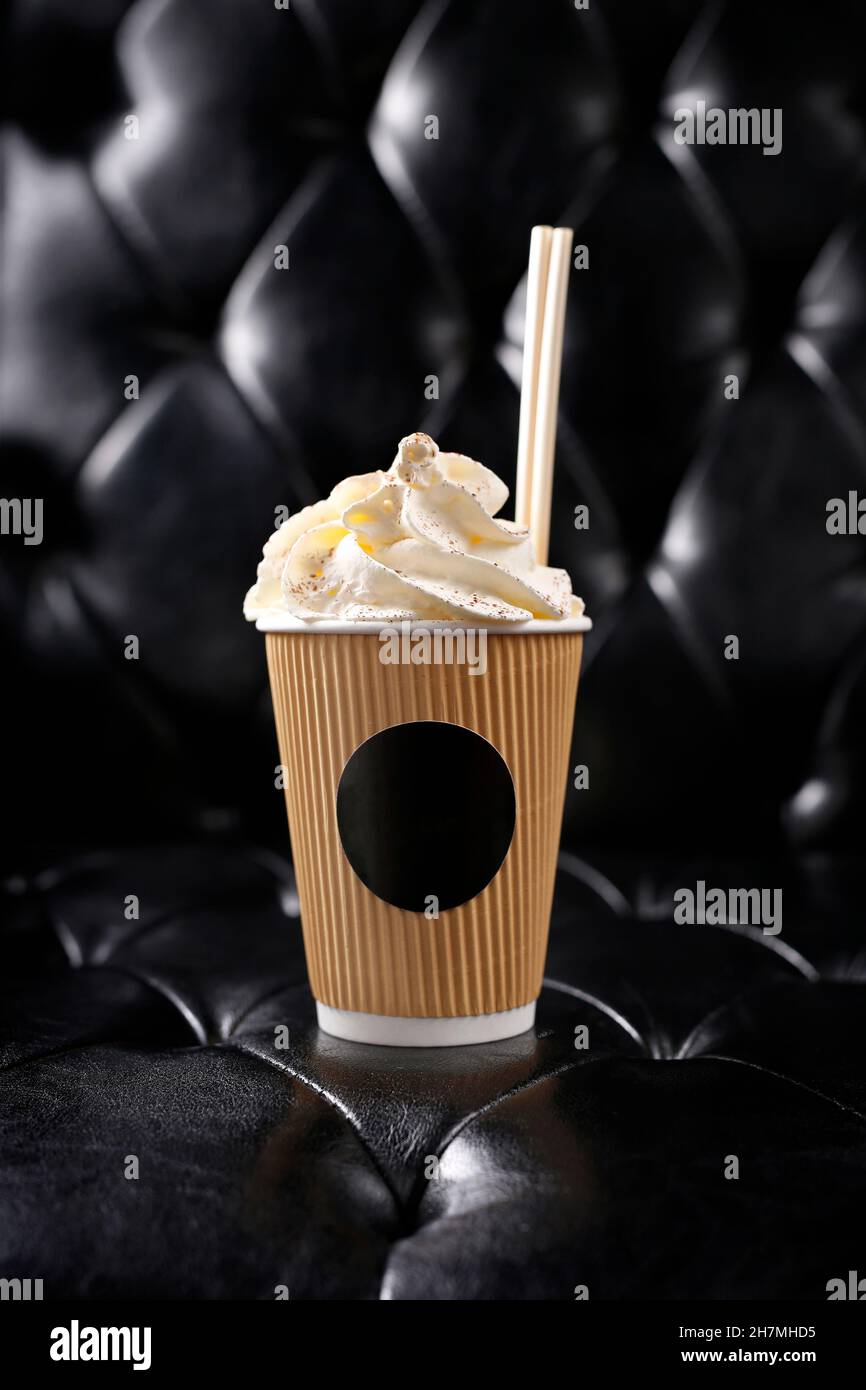 Coffee with whipped cream in a takeout cup. Place for the logo. A tasty dish.Culinary photography. Suggestion to serve the dish. Stock Photo