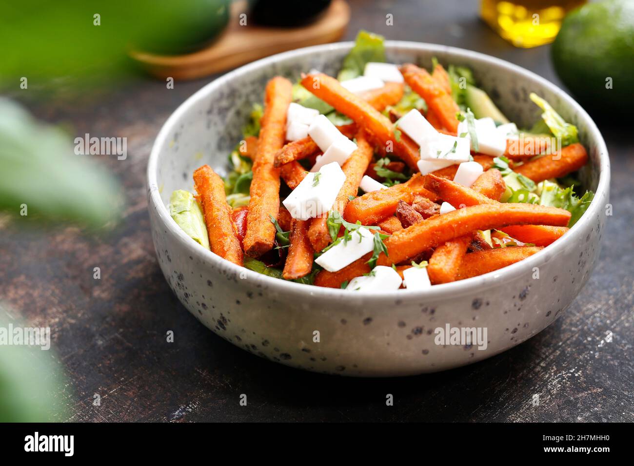 Sweet potato fries on green lettuce. Appetizing dish. Culinary photography, a proposal to serve a meal. Stock Photo