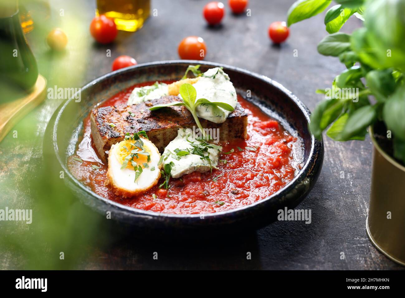 Vegetable casserole in tomato sauce with egg and white cheese. A tasty dish.Culinary photography. Suggestion to serve the dish. Stock Photo