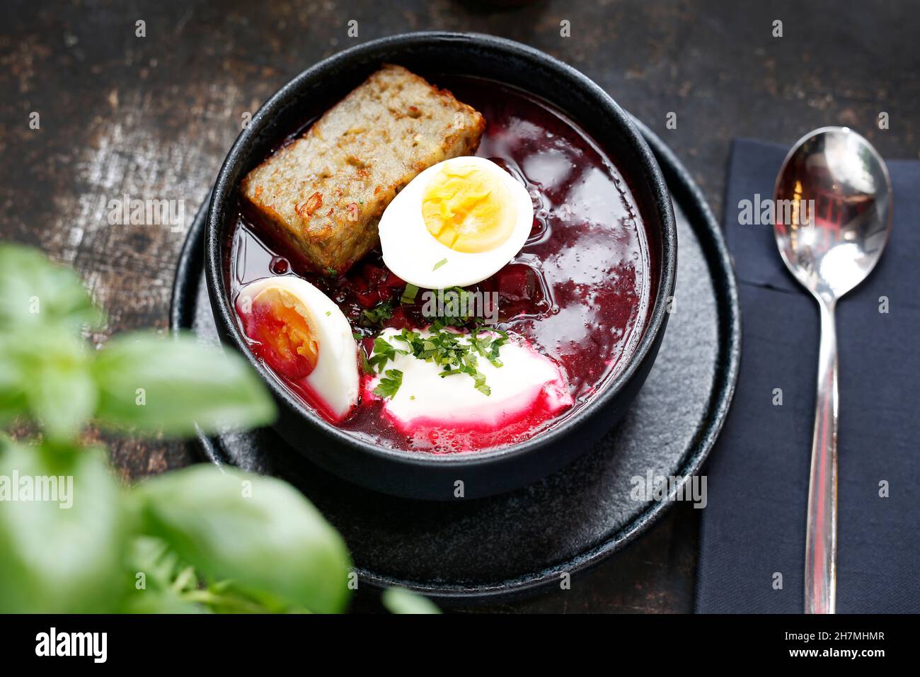 Beet soup with egg. Appetizing dinner dish. Culinary photography, a proposal to serve a meal. Stock Photo