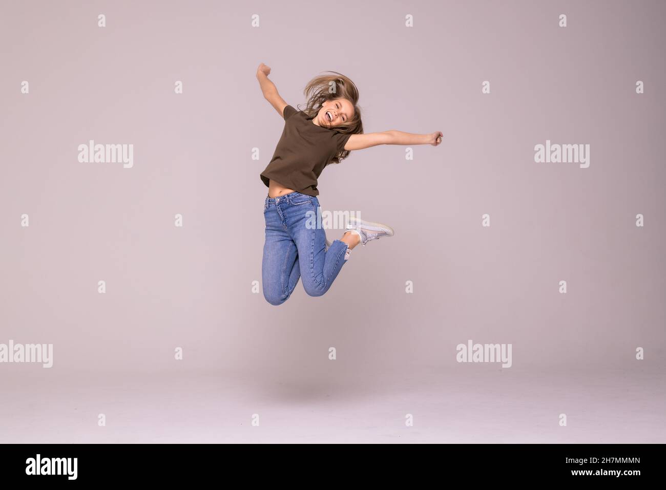Full length portrait of a cheerful woman jumping isolated on a white ...