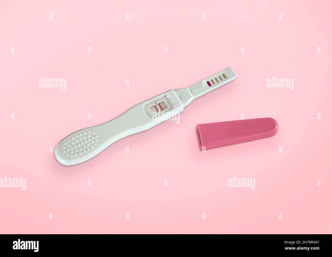 Pregnancy test with two stripes on pastel pink background. Positive result Stock Photo