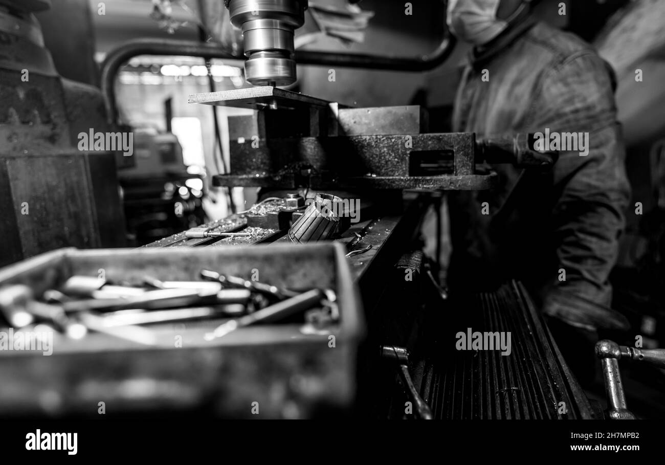 Milling machine working near worker with a protective mask. Tool for
