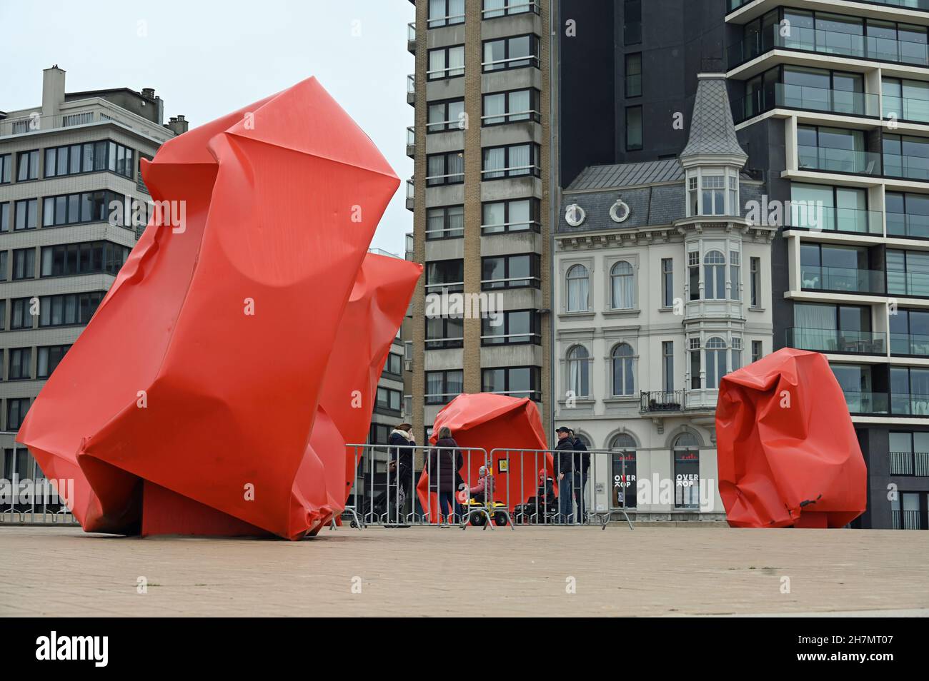 Orange-red abstract sculptures in front of gray facades on the Ostend waterfront Stock Photo