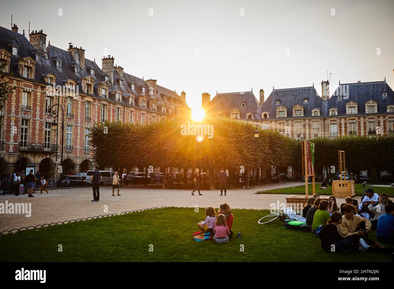 Evening atmosphere with fountains in front of medieval facades. View to the Square Louis-XIII to the west into the setting sun. Place des Vosges Stock Photo