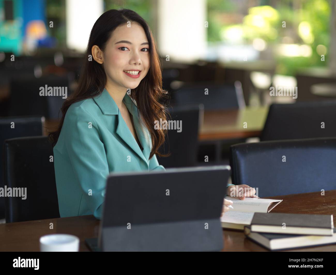 Professional young female manager working on digital tablet computer at co-working space. Stock Photo